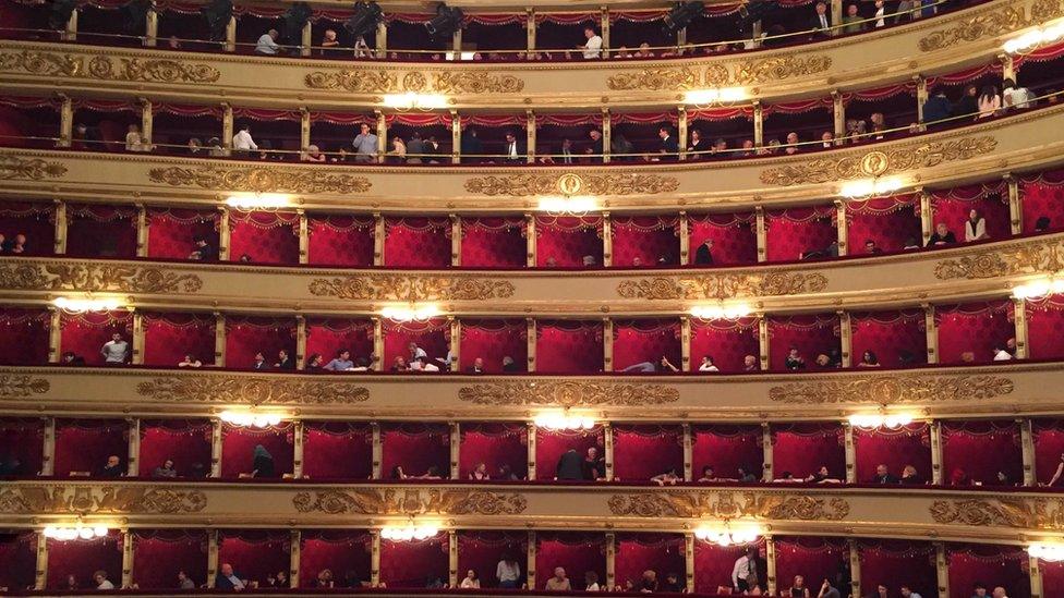 An opera audience in their booths