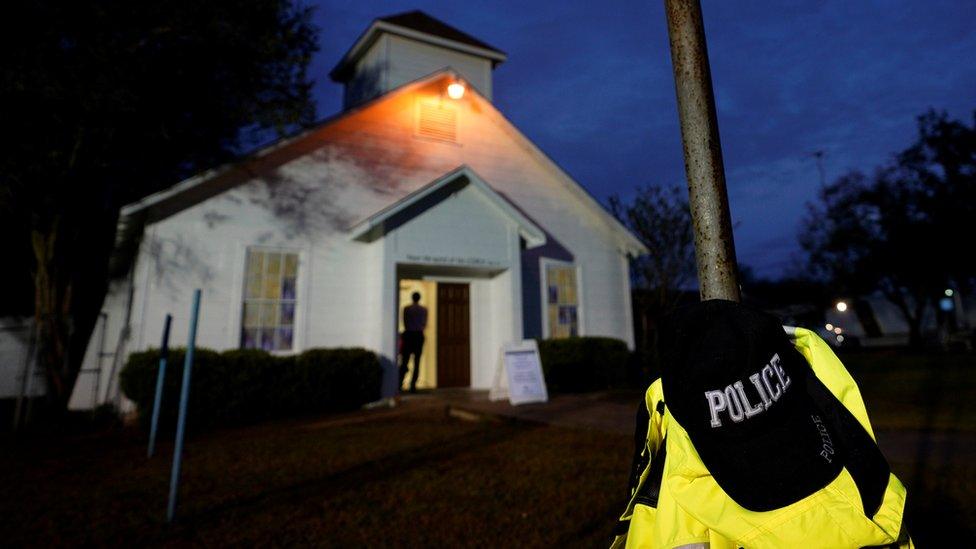 A police hat hangs outside the white exterior of the church