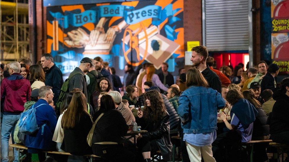 People sitting at tables at festival