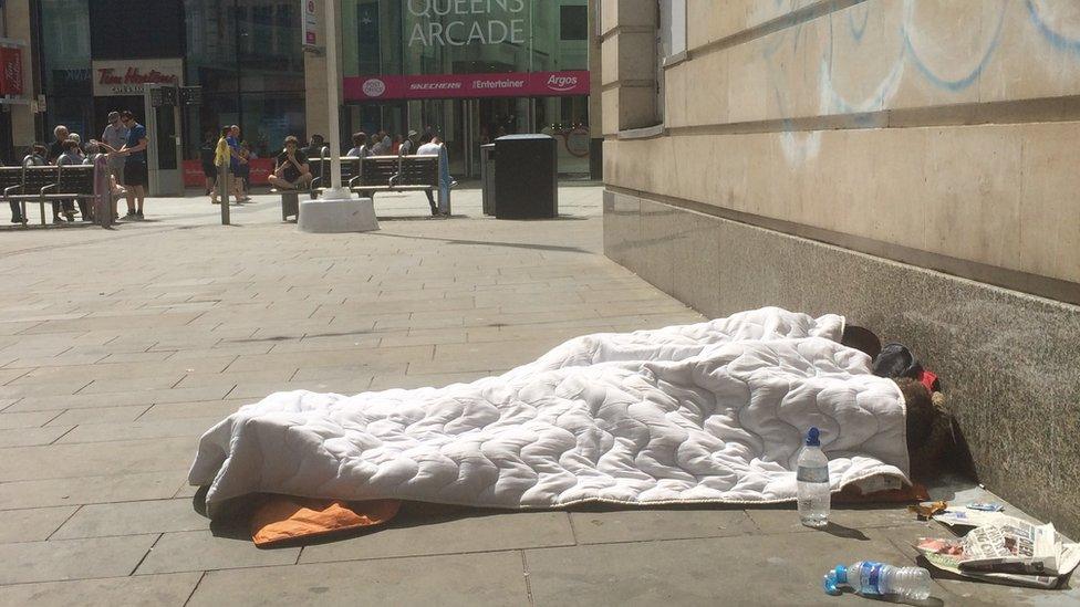 A homeless person trying to get shade in Cardiff