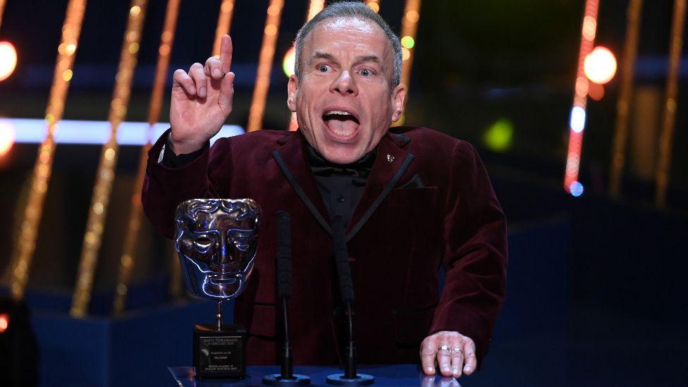 Warwick Davis accepts the Fellowship Award on stage during the EE BAFTA Film Awards 2025 at The Royal Festival Hall on February 16, 2025 in London, England. 