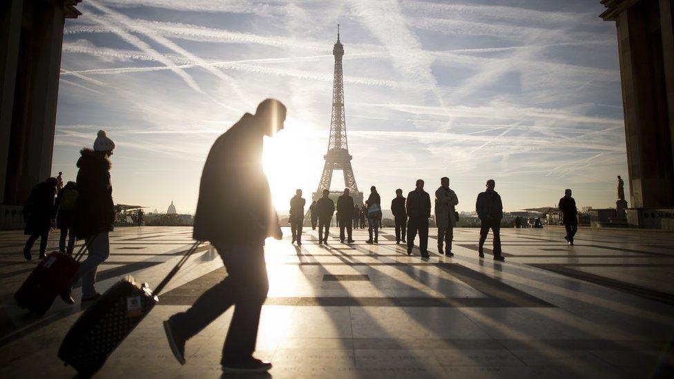 Pedestrians walking in front of Eiffel Tower