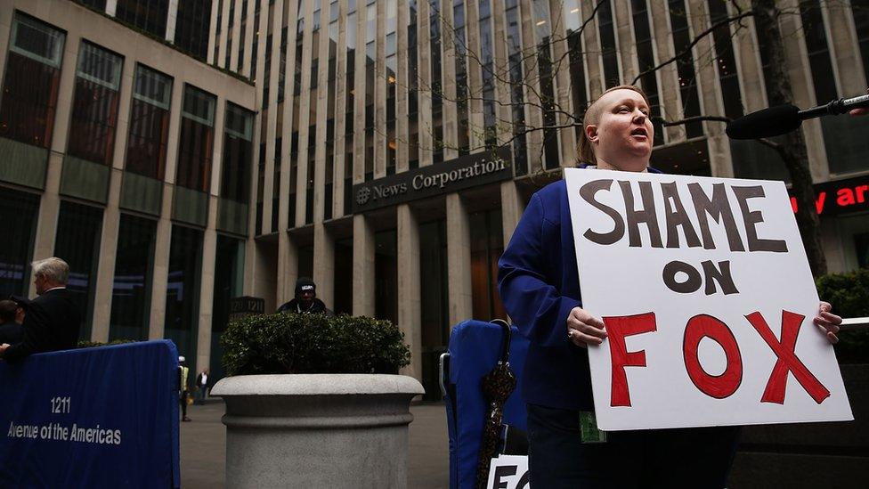 A protester stands outside of News Corp. in New York