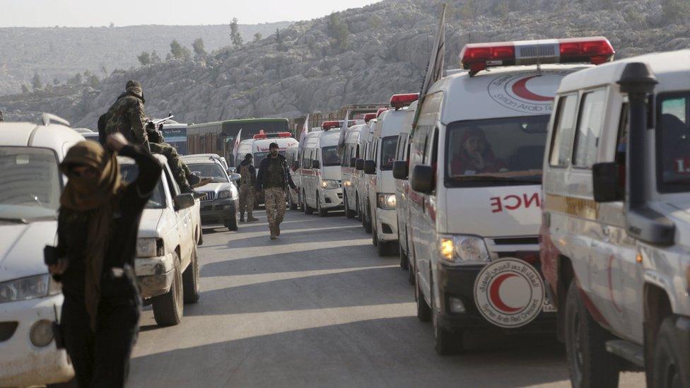 Syrian rebel fighters escort Red Crescent ambulances and coaches from Foah and Kefraya, in Idlib province (28 December 2015)