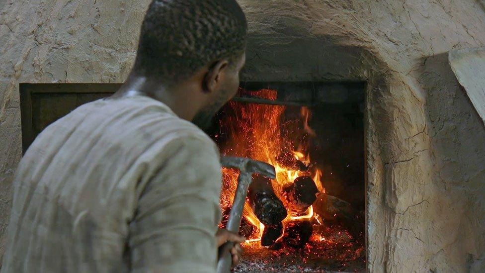 A man tends the bakery fire