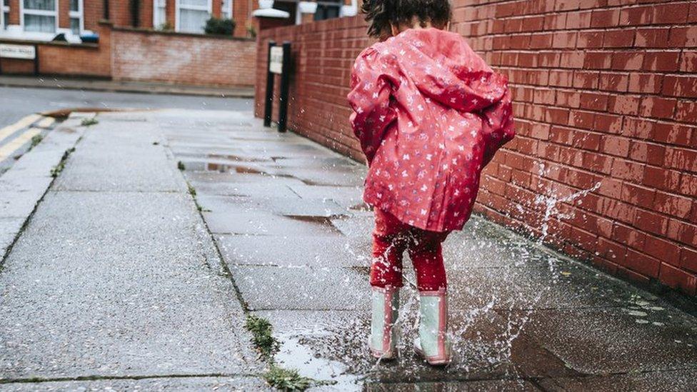 Girl splashing in puddle