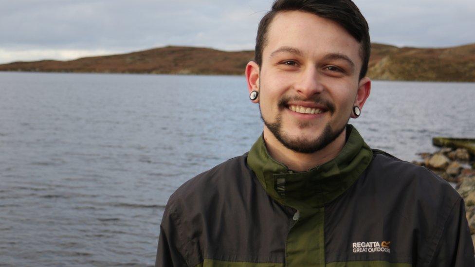 Liam smiling and standing by the sea