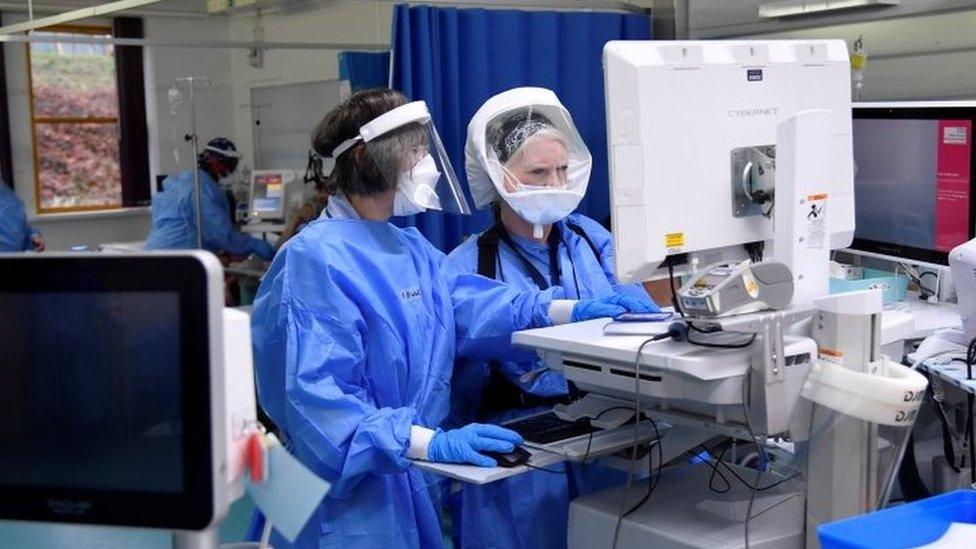 Nurses monitor patients on a COVID-19 ward