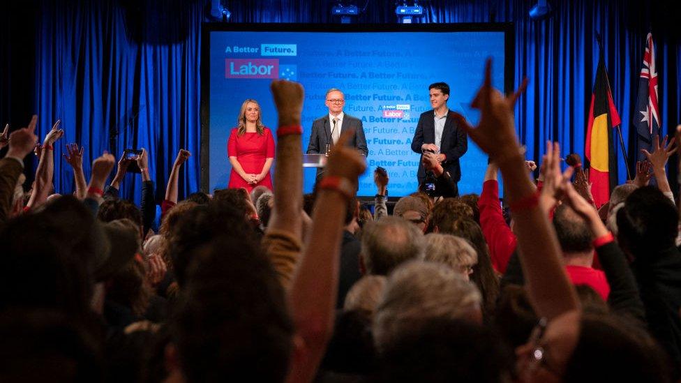 A crowd cheers Anthony Albanese on stage