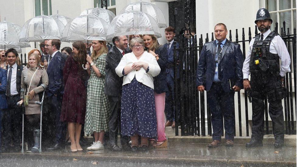 Supporters wait in the rain for Liz Truss to arrive and give her speech.