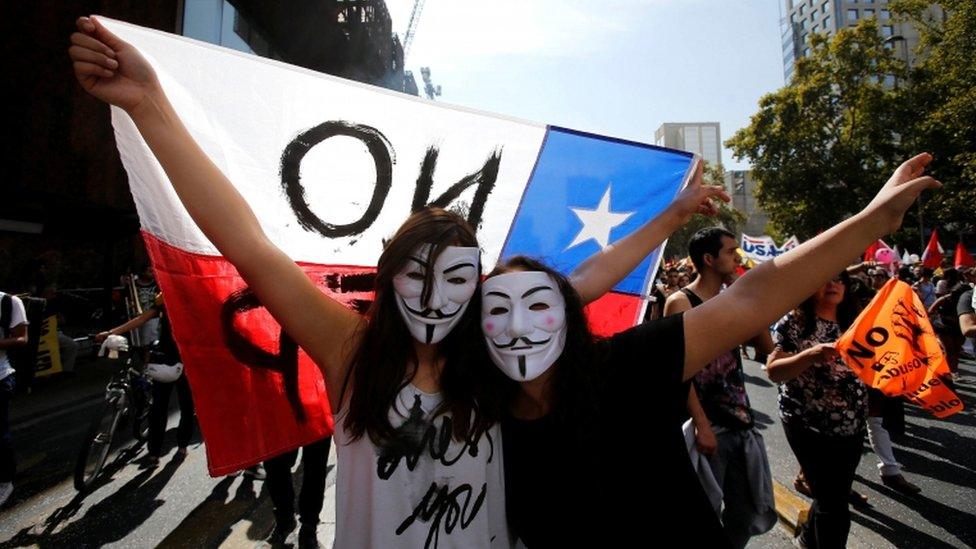 Demonstrators wear Guy Fawkes masks during a march against the national pension system, in Santiago, Chile