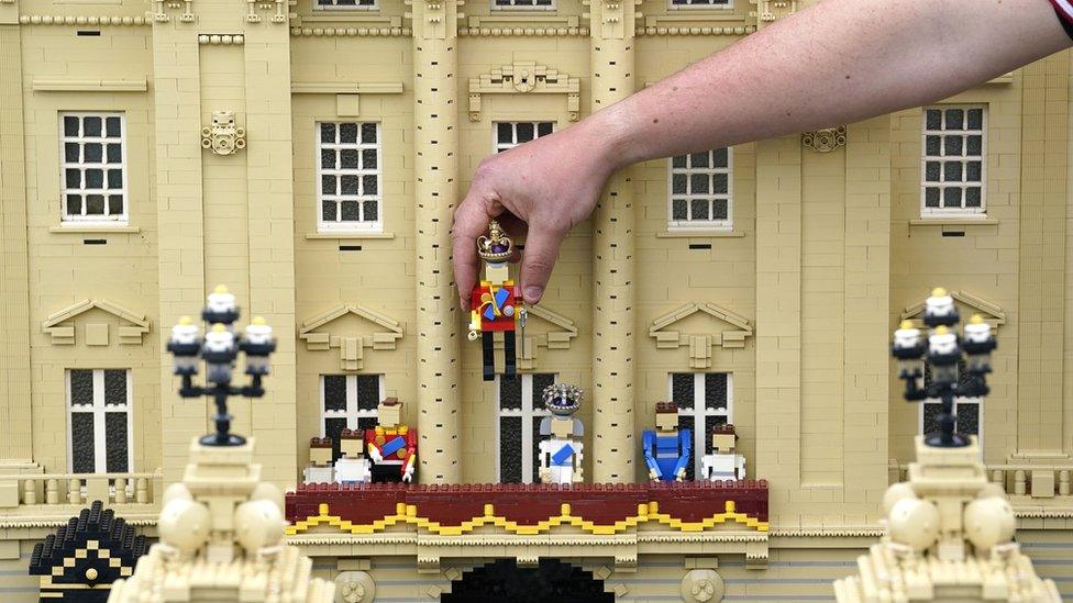 Model maker Daniel Anderson from the Legoland Windsor Resort, places a Lego model of King Charles III onto the balcony of Buckingham Palace as part of a coronation miniland scene,