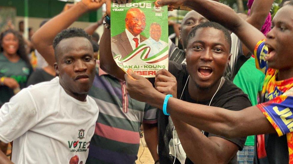 People holding up a campaign poster