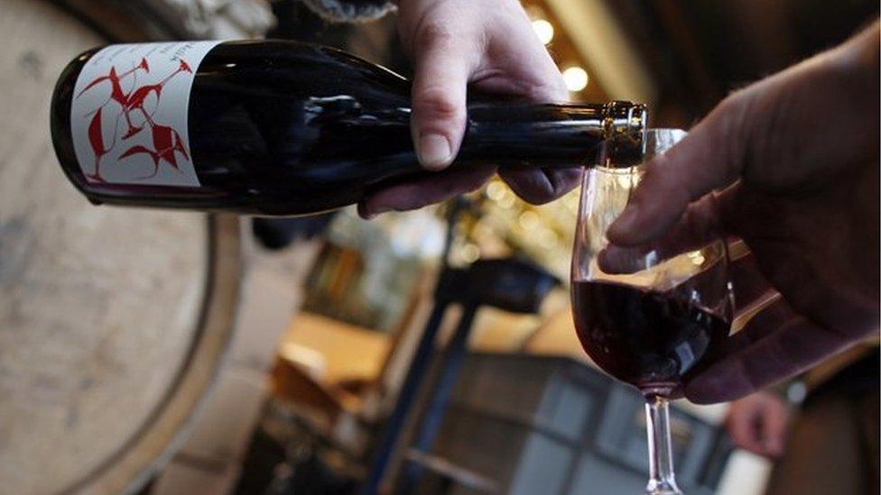 Wine is poured from a bottle of Beaujolais Nouveau