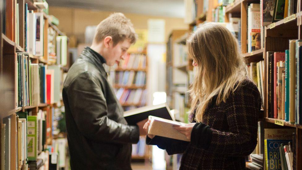 A man and woman reading in a bookshop