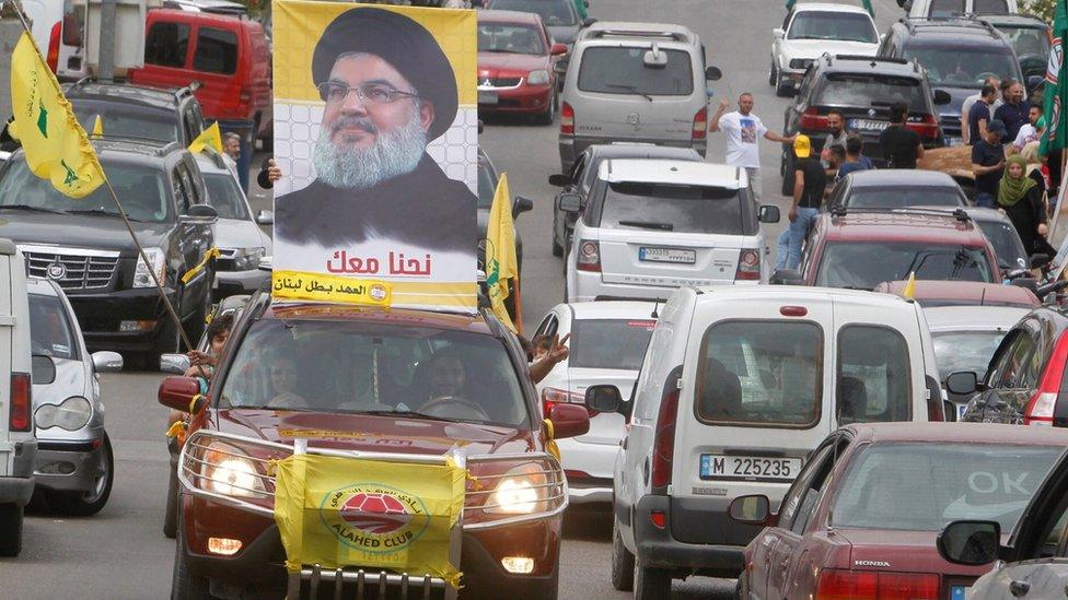 A man carries a picture of Hezbollah leader Hassan Nasrallah on election day in Bint Jbeil, in southern Lebanon, on 6 May 2018