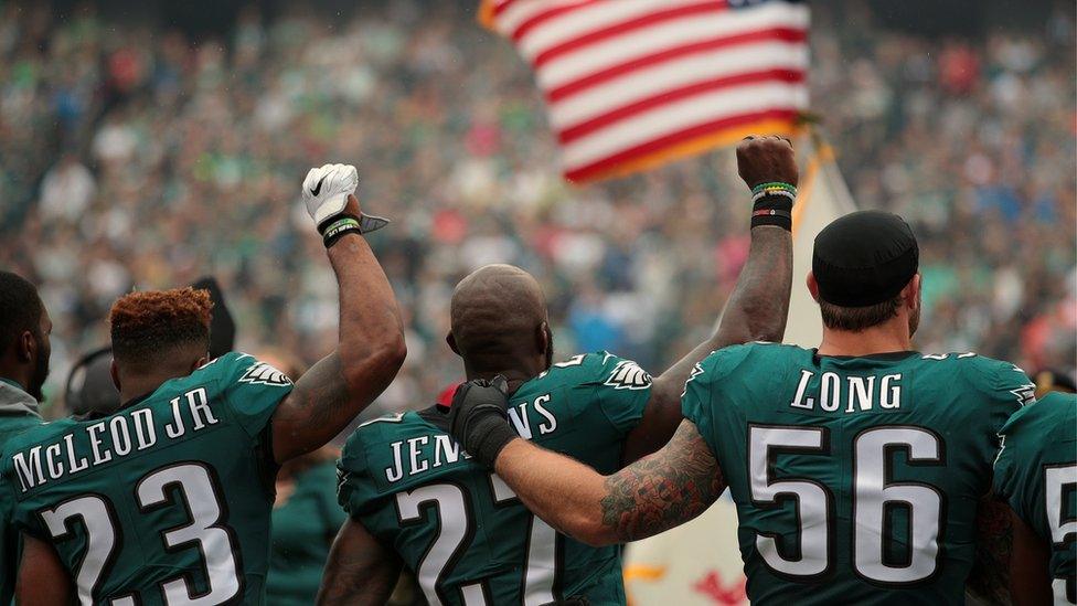 Rodney McLeod #23, Malcolm Jenkins #27 of the Philadelphia Eagles raise their fists in protest during the playing of the National Anthem as teammate Chris Long #56 shows support before a game against the Arizona Cardinals.