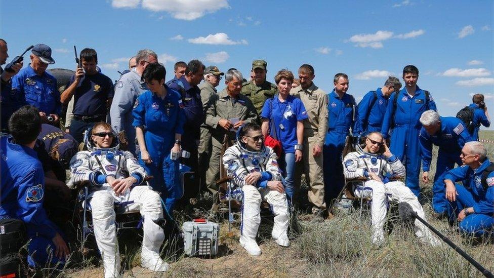 Tim Peake from Britain, Yuri Malenchenko from Russia and Tim Kopra from the US rest in chairs shortly after landing