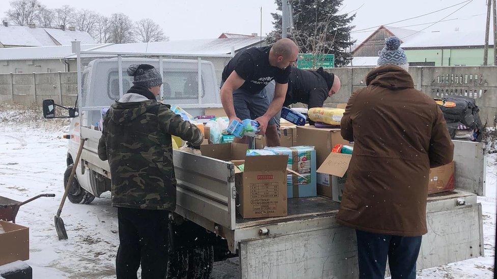 The team loading a small truck with aid in Poland