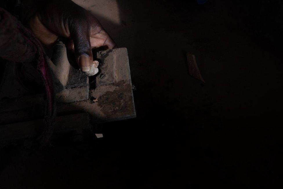 Kumus Da Silva de-shells a cashew nut at his small scale factory just outside the capital. The first year he made cashew juice he did not turn a profit, but now when they sell it to local restaurants they make 500 cfa per bottle (which sell for 2500 cfa).