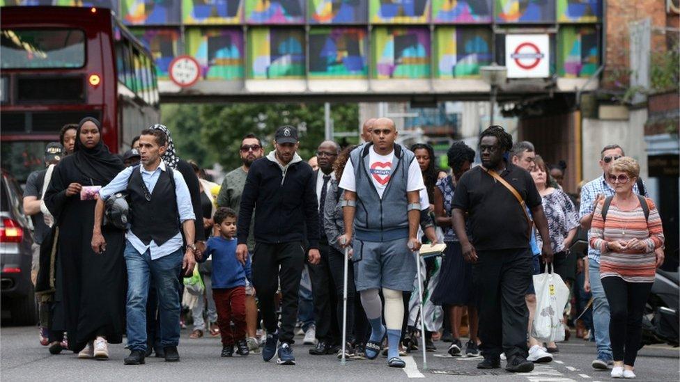 A silent march to pay respect to those killed in the Grenfell Tower disaster makes its way down Ladbroke Grove