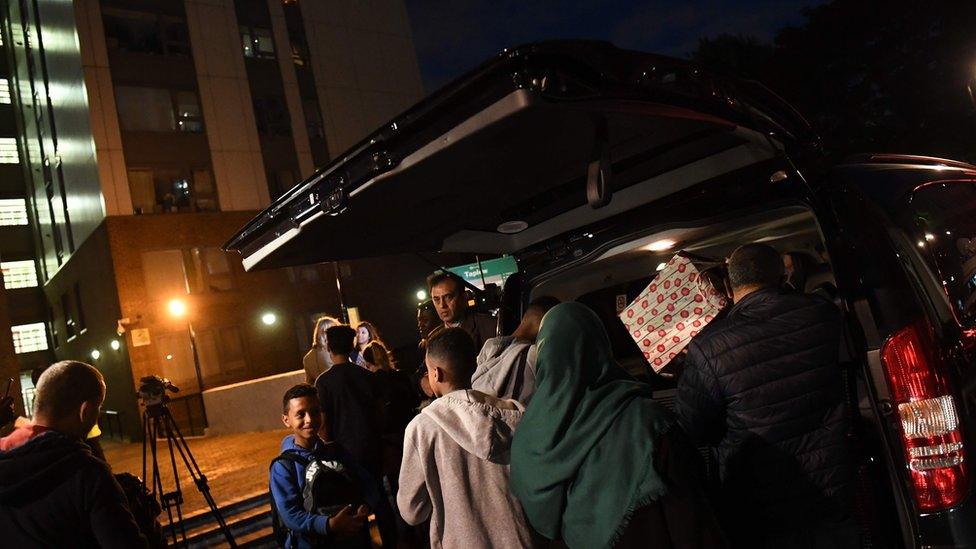 People packing their belongings into a taxi