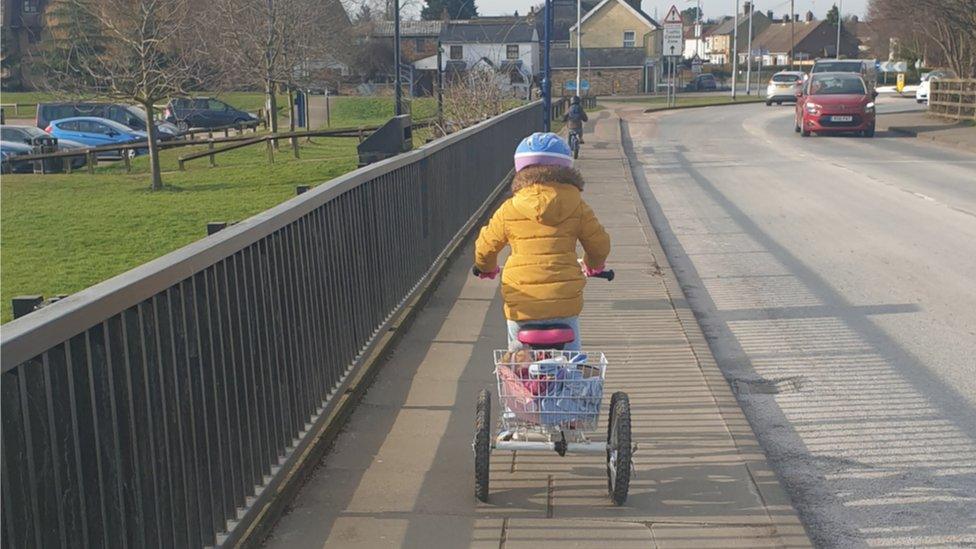 Isla riding her trike