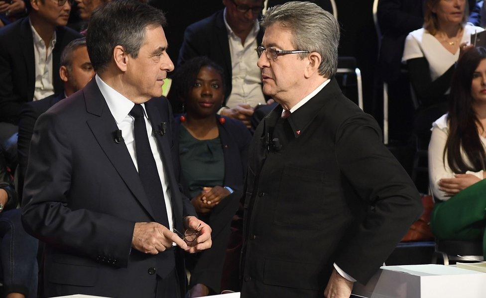 Jean-Luc Mélenchon (R) speaks with Republican candidate François Fillon