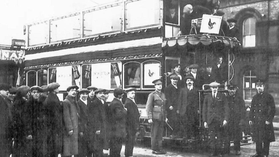 Men queue outside tram