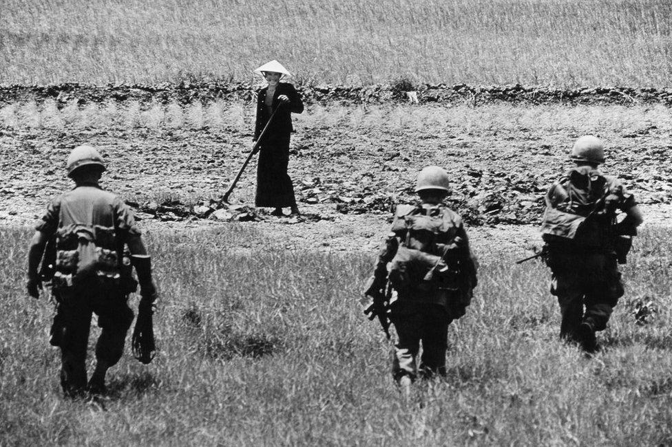 Soldiers approach an agricultural worker