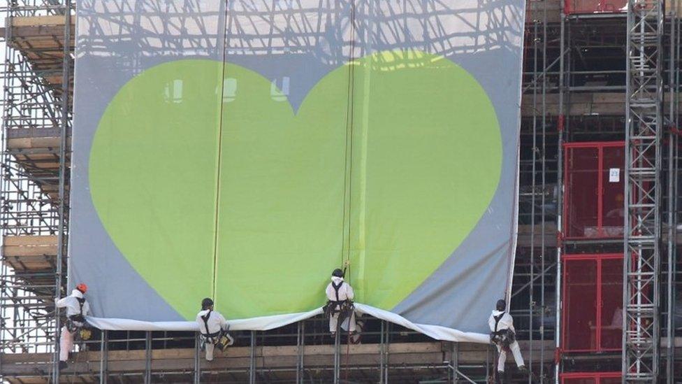 Banner is unveiled on the outside of Grenfell Tower