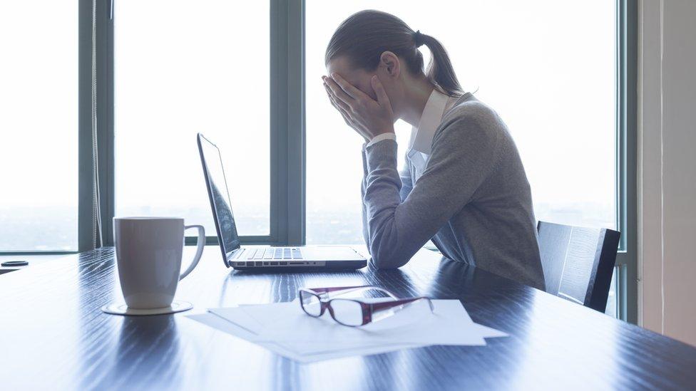 Office worker with head in hands