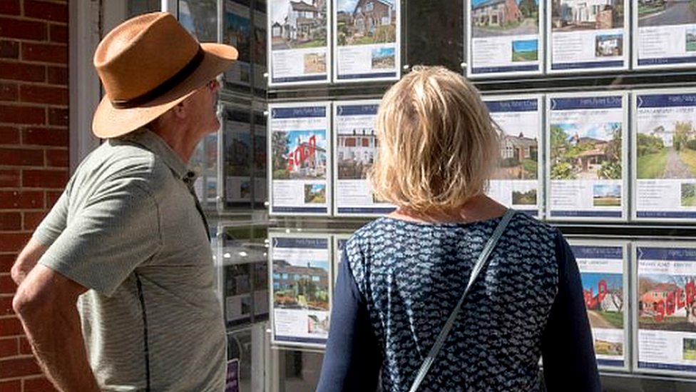 People look in real estate agency window