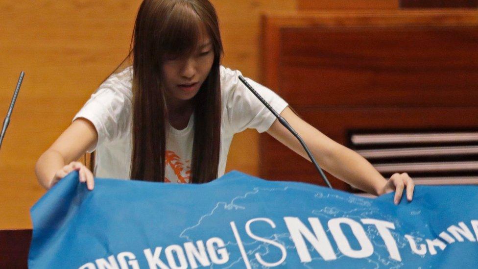 A newly elected lawmaker, Youngspiration's Yau Wai-ching, displays a banner with words reading "Hong Kong is not China" as she takes oath in the new legislature Council in Hong Kong, 12 Oct 2016