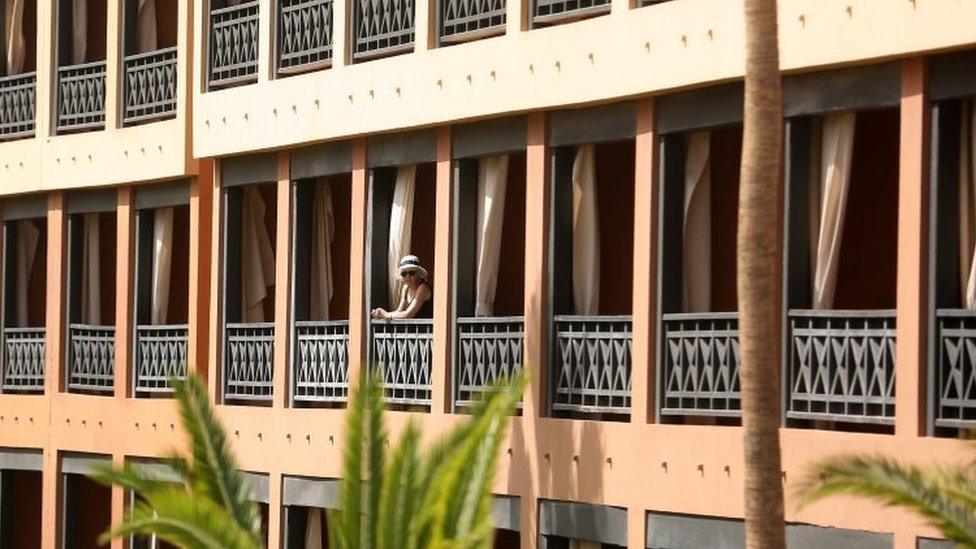 A tourist looks on from her balcony at a quarantined hotel in Tenerife