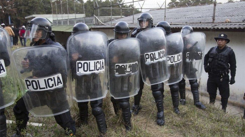 Police stand guard after an operation to rescue four hostages during a prison riot at a youth detention centre near Guatemala City on March 20, 2017.