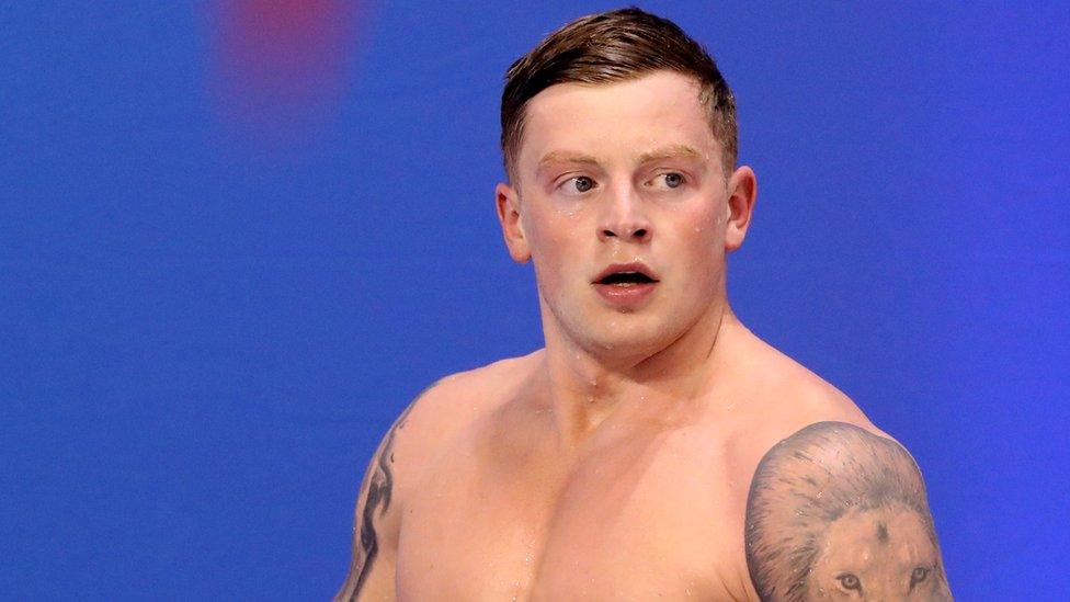 adam peaty looks to his left after leaving a swimming pool