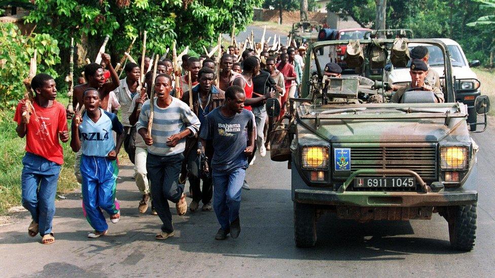 A file picture taken 27 June 1994 shows French soldiers on patrol passing ethnic Hutu troops from the Rwandan government forces, near Gisenyie, about 10km from the border with DR Congo, then Zaire