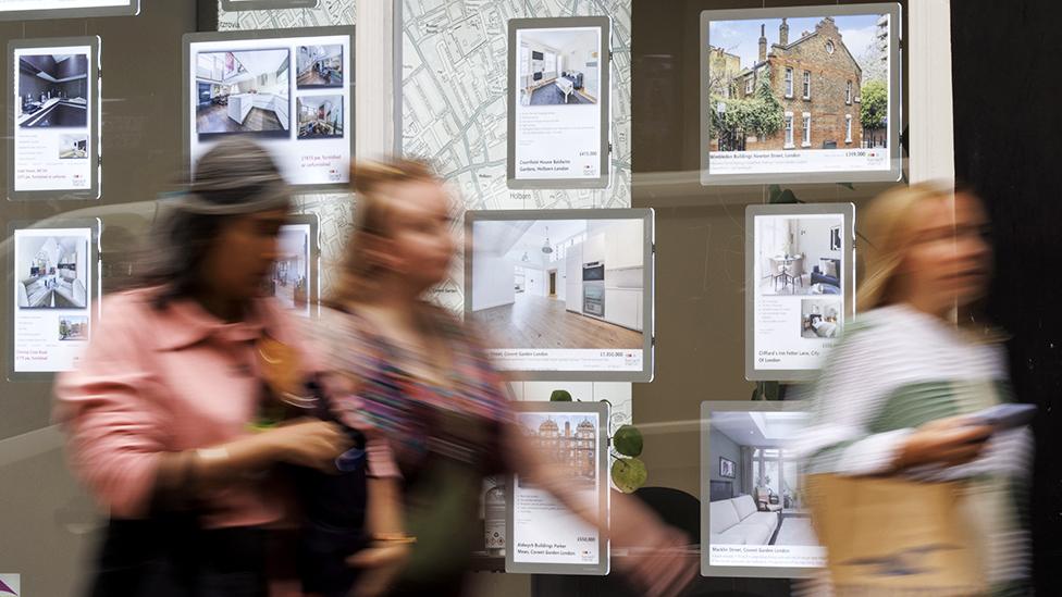 People walk past an estate agents window in London on 5 October