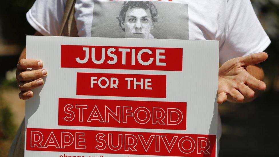 A woman holds a sign saying "Justice for the Stanford Rape survivor"