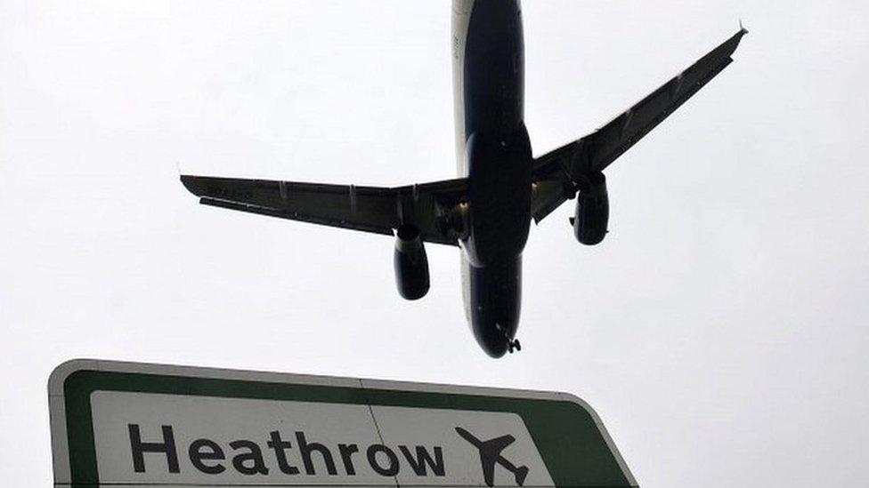 Plane flying over Heathrow sign