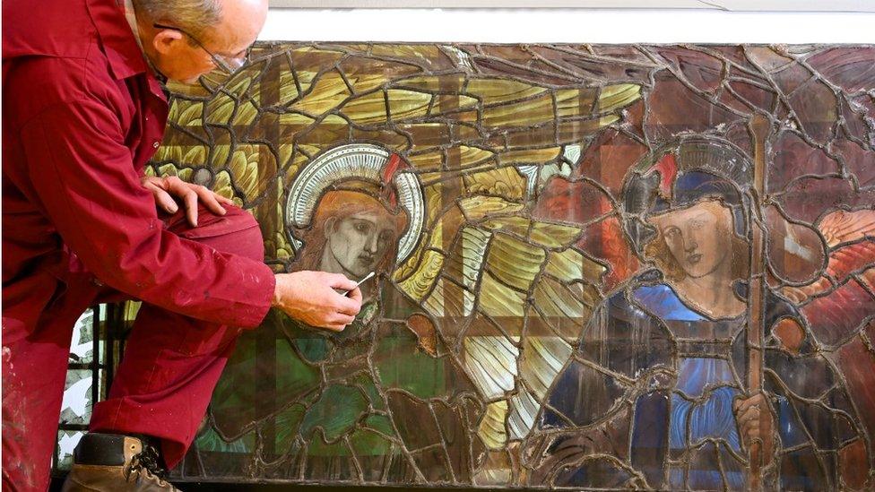 Glass conservators take an initial look at the stained glass figures in the cathedral workshop