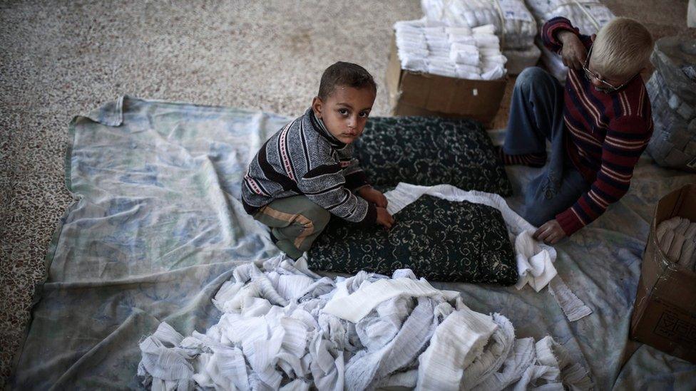 Young Syrians roll gauze for medical dressings at a small factory in rebel-held Douma, outside Damascus, Syria (6 December 2015)