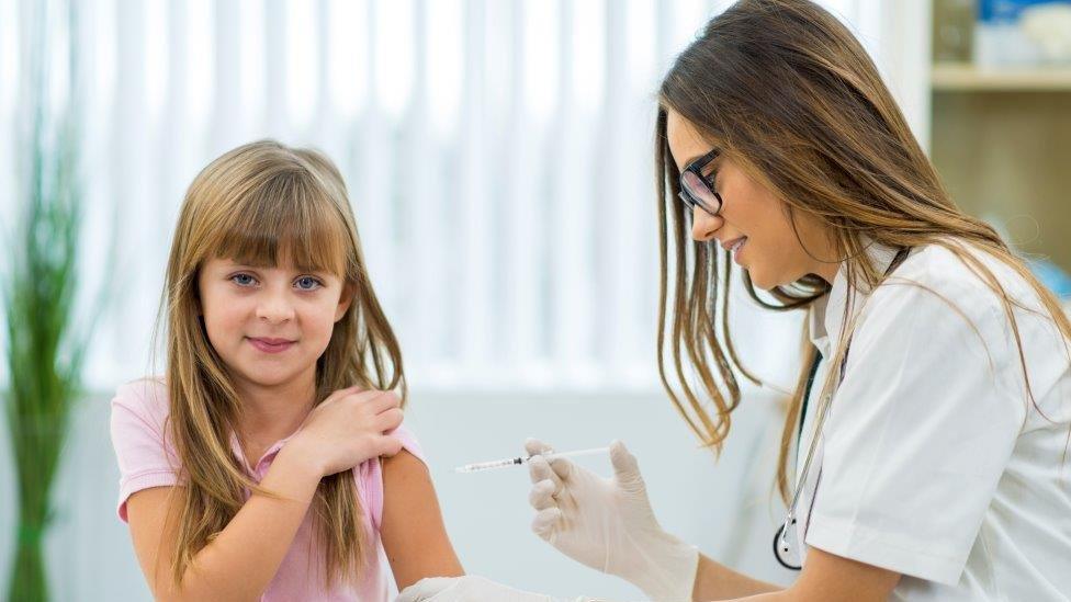 Girl getting vaccine or insulin shot.