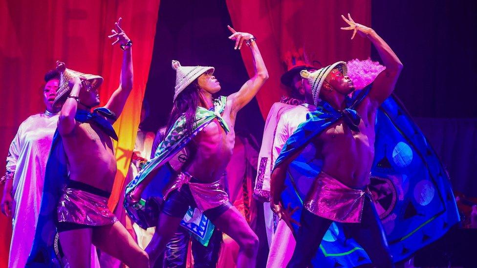 Three dancers on stage striking a pose