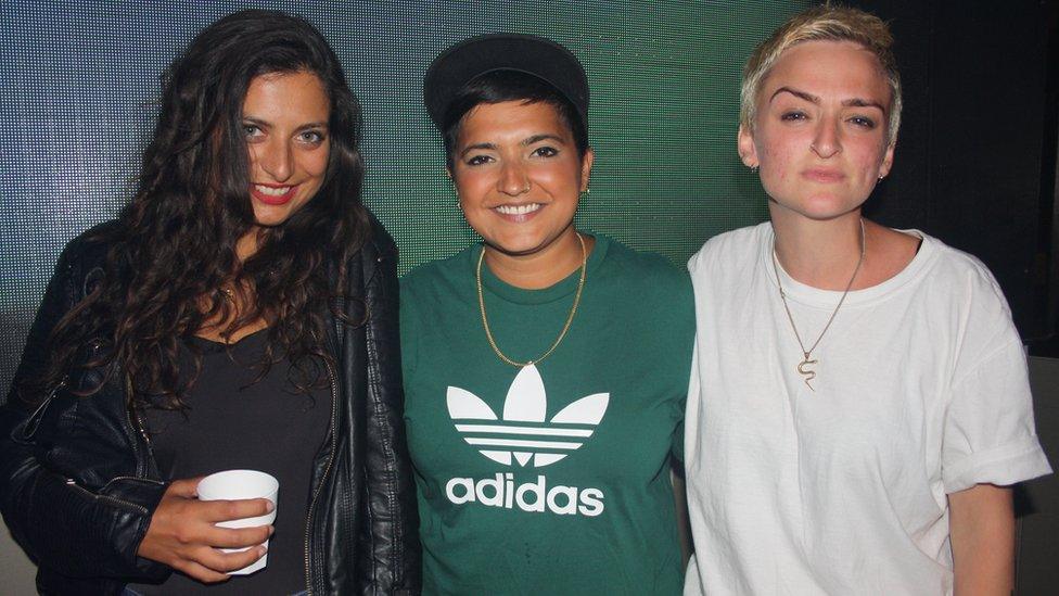 Three smiling women in a club.