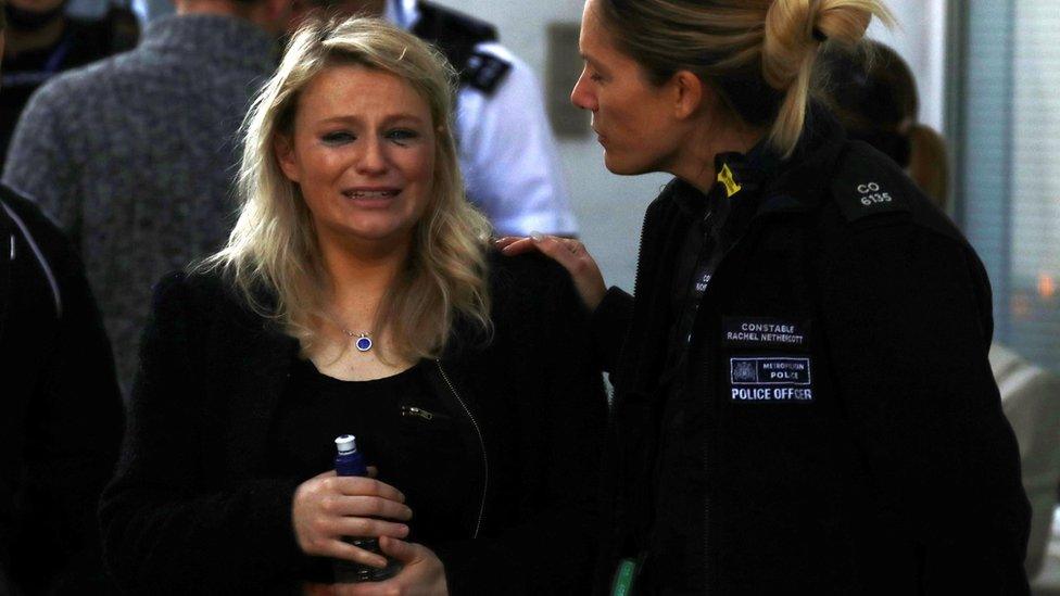 A woman was comforted by a police officer outside Parsons Green station