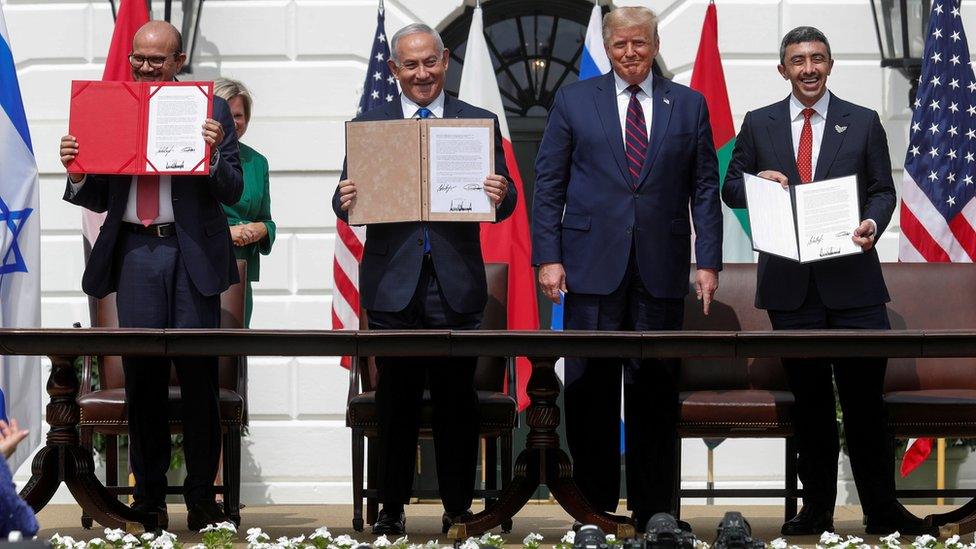 Bahraini Foreign Minister Abdullatif bin Rashid Al-Zayani, Israeli Prime Minister Benjamin Netanyahu and United Arab Emirates Foreign Minister Sheikh Abdullah bin Zayed display their copies of the Abraham Accords as US President Donald Trump looks on, at a ceremony at the White House (15 September 2020)