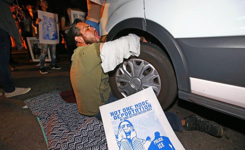 Protester locks himself to a van carrying Guadalupe Garcia de Rayos that is stopped by protesters in Phoenix, Arizona. 8 Feb 2017