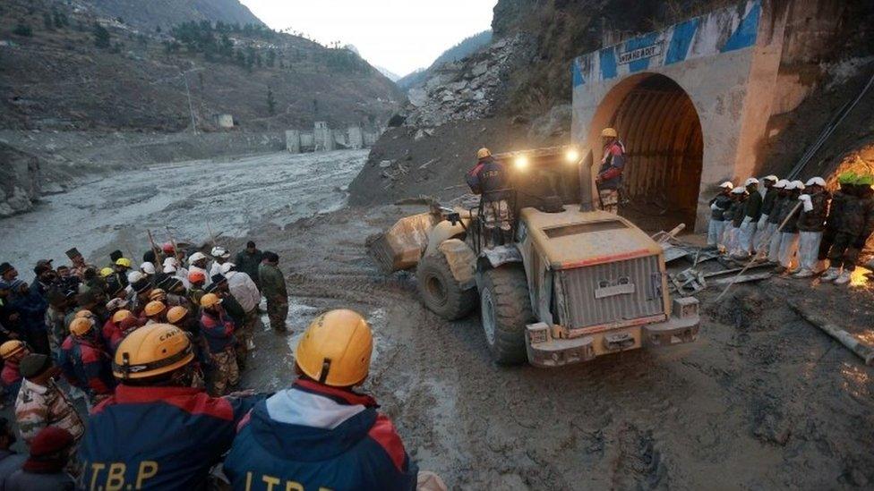 Members of Indo-Tibetan Border Police (ITBP) watch as a machine is used to clear a tunnel after a part of a glacier broke away, in Tapovan in the northern state of Uttarakhand, India, February 8, 2021